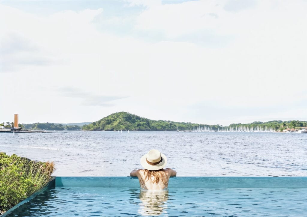 Basseng-med-utsikt-mot-Hovedoya-Atelier-Oslo-1024x724 Woman in infinity pool looking out at mountain